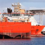 Fleet of offshore vessels moored in Norwegian port at sunny day